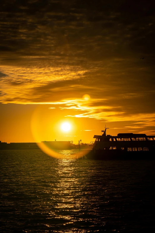 the sun setting over a boat in the water