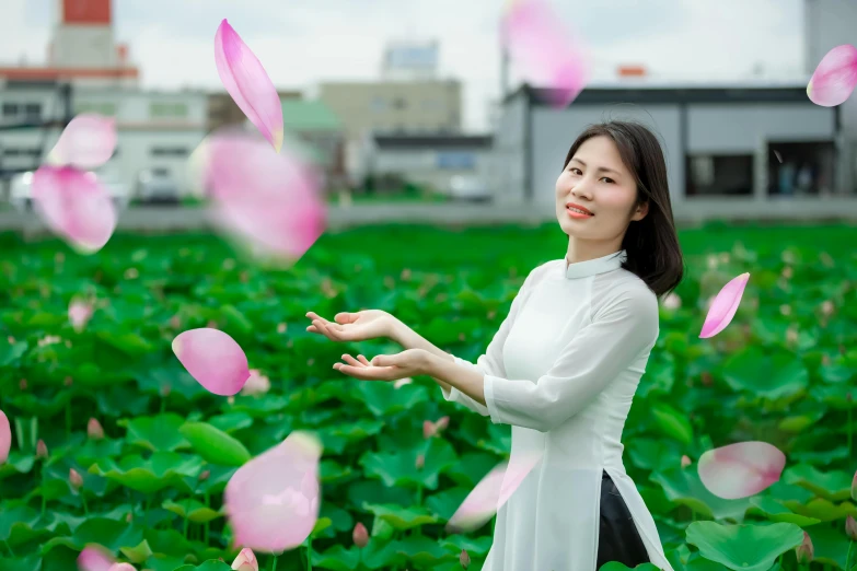 a woman in white dress with red flowers and pink petals