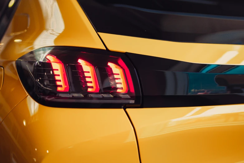 rear light of yellow car on street in urban setting