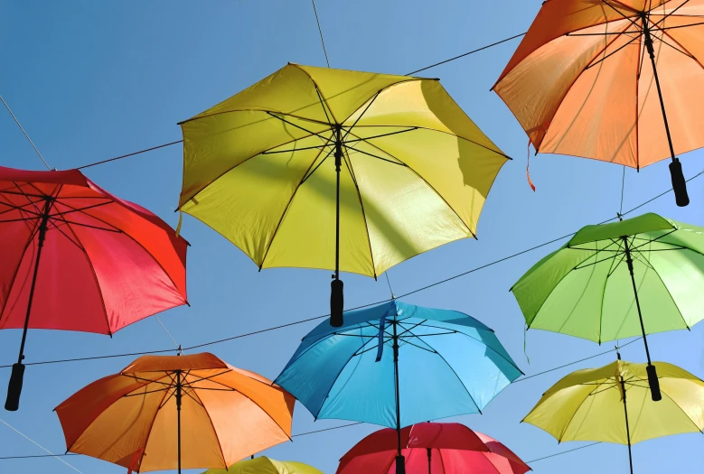 many umbrellas are seen floating high in the air