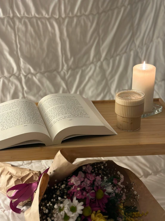 two book sitting next to each other on a bed with flowers in the room