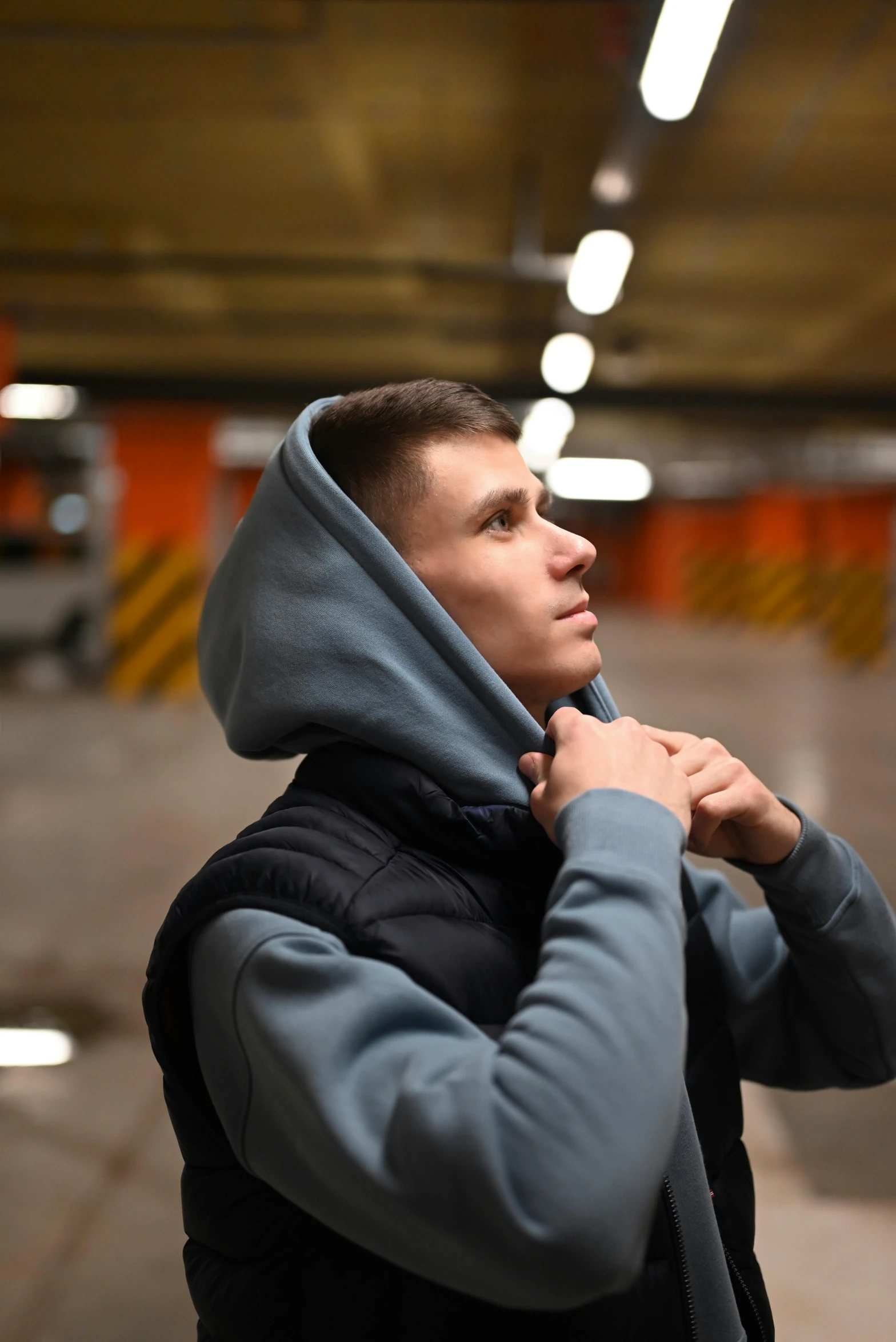 a man is putting on his coat in a parking garage