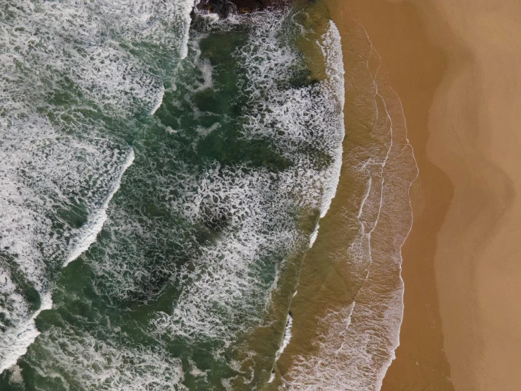 some waves are breaking onto an empty beach