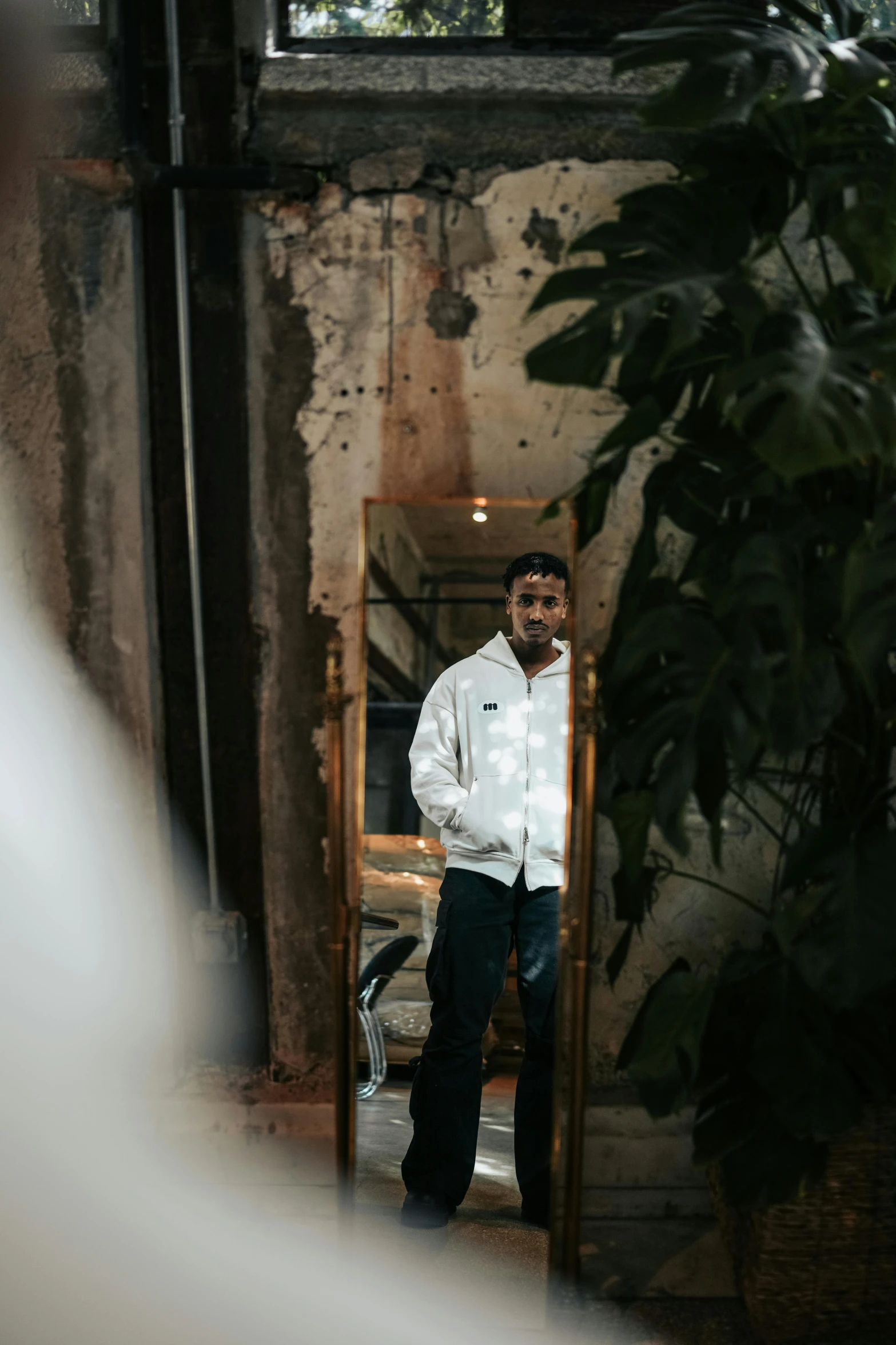 a man standing in front of a mirror near trees