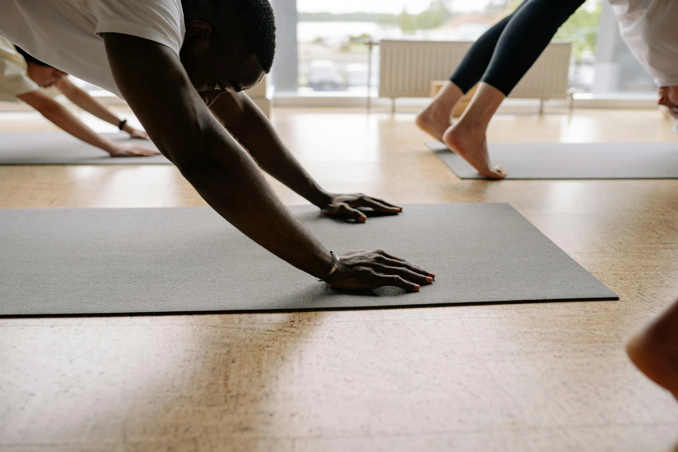 two people stand on a yoga mat while holding onto one of their feet