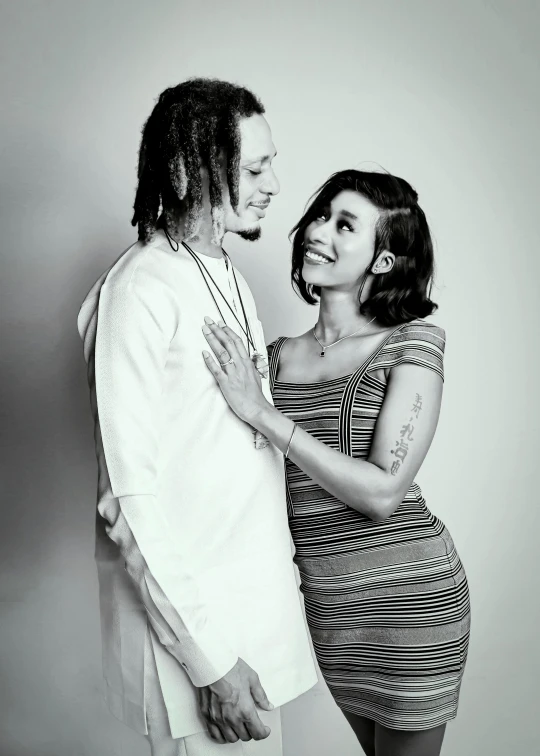 a woman standing next to a man with dreadlocks on