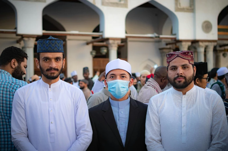 a group of people with face coverings and one wearing a blue mask