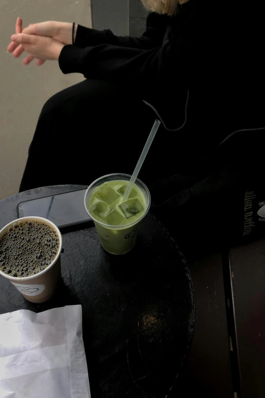 a black table with a cup of green tea