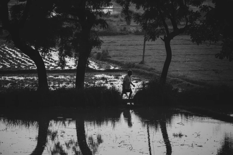 there are two men walking in the water with their dog