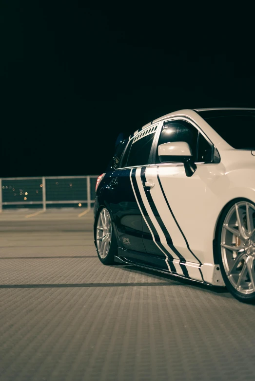 an all white car with some stripes and chrome rims