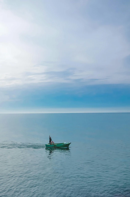 a couple of people riding in a green boat