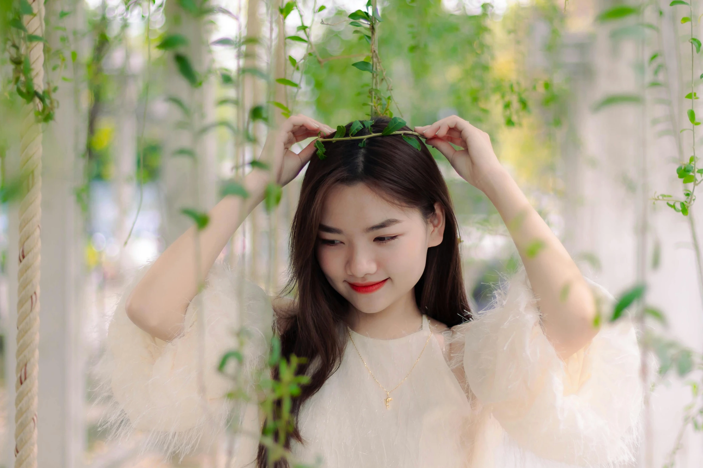 the woman is standing between tall grass and trees