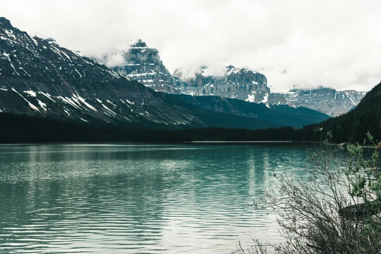 large lake surrounded by snow covered mountains in the background