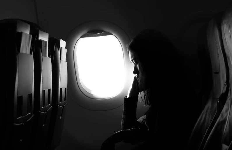 black and white pograph of a woman on an airplane