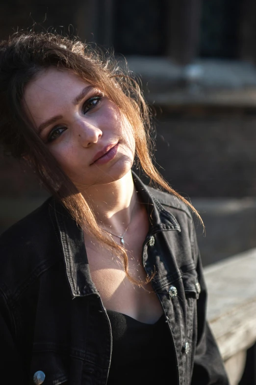 a woman poses outside, with her hair down