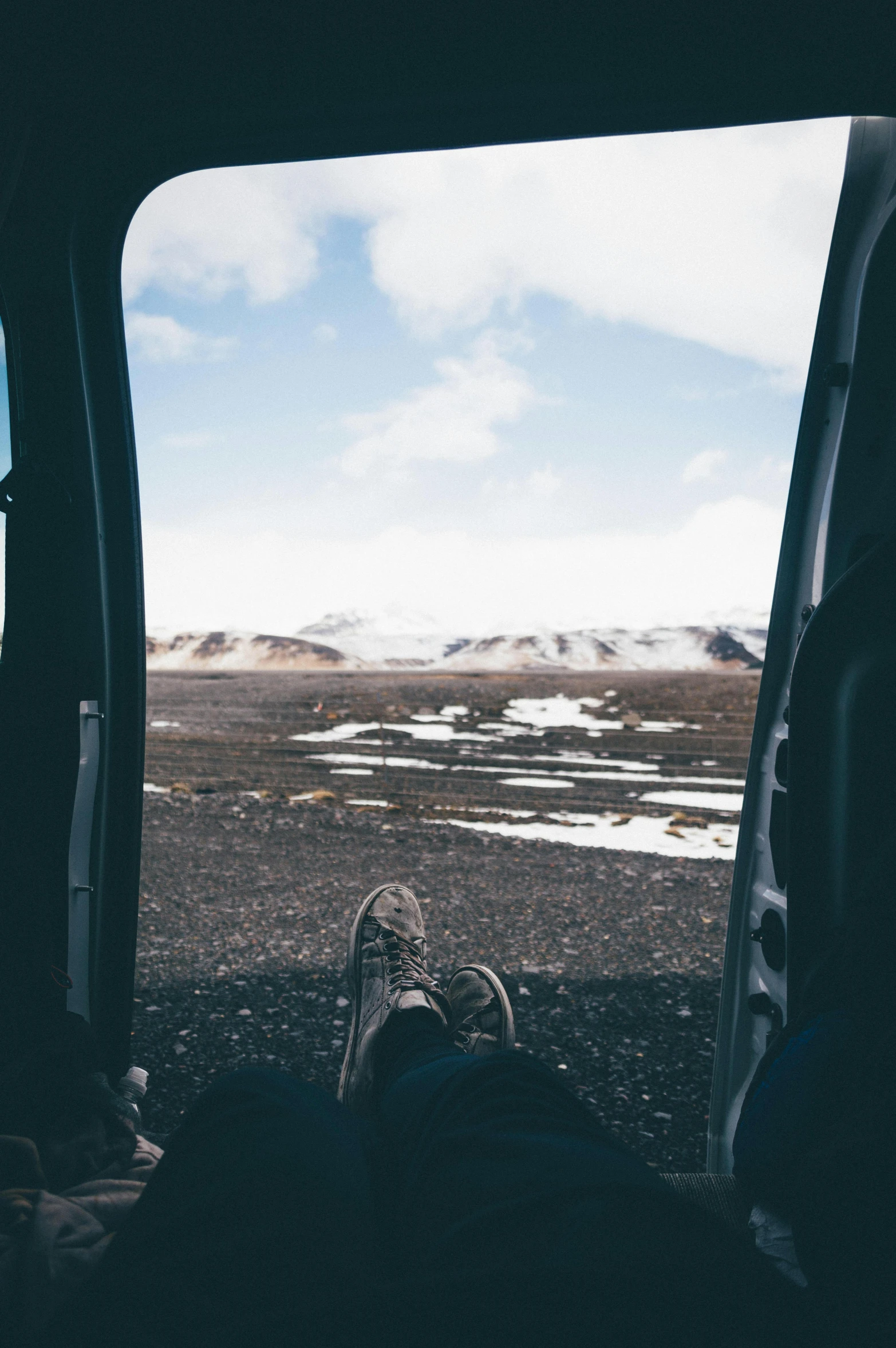 person's feet sitting in the car looking out into the mountains