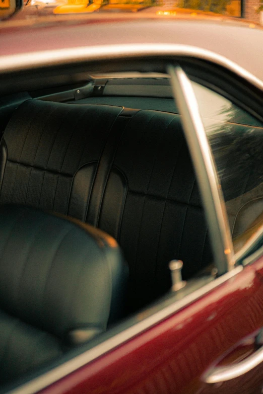 a red car with a cat sitting in the passenger seat