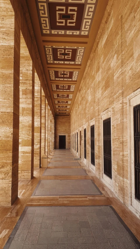 a long walkway with several windows under an orange ceiling