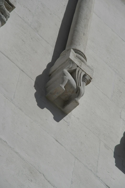 the concrete corner of a building with an artistic figure on it
