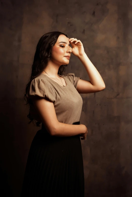 a young woman posing with her hand on her face