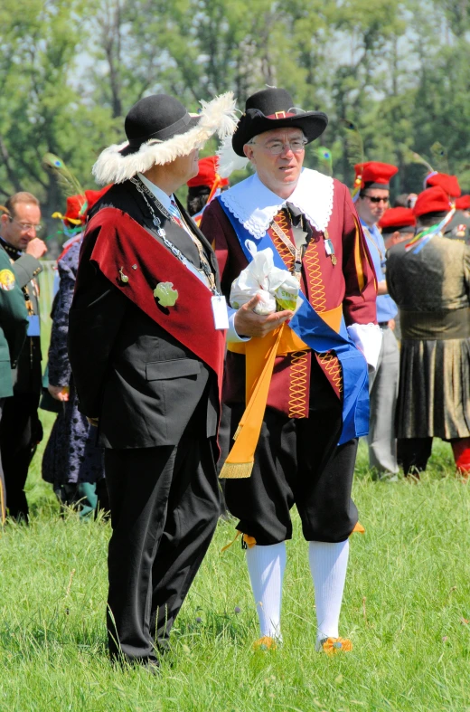 two men in traditional costume stand beside each other