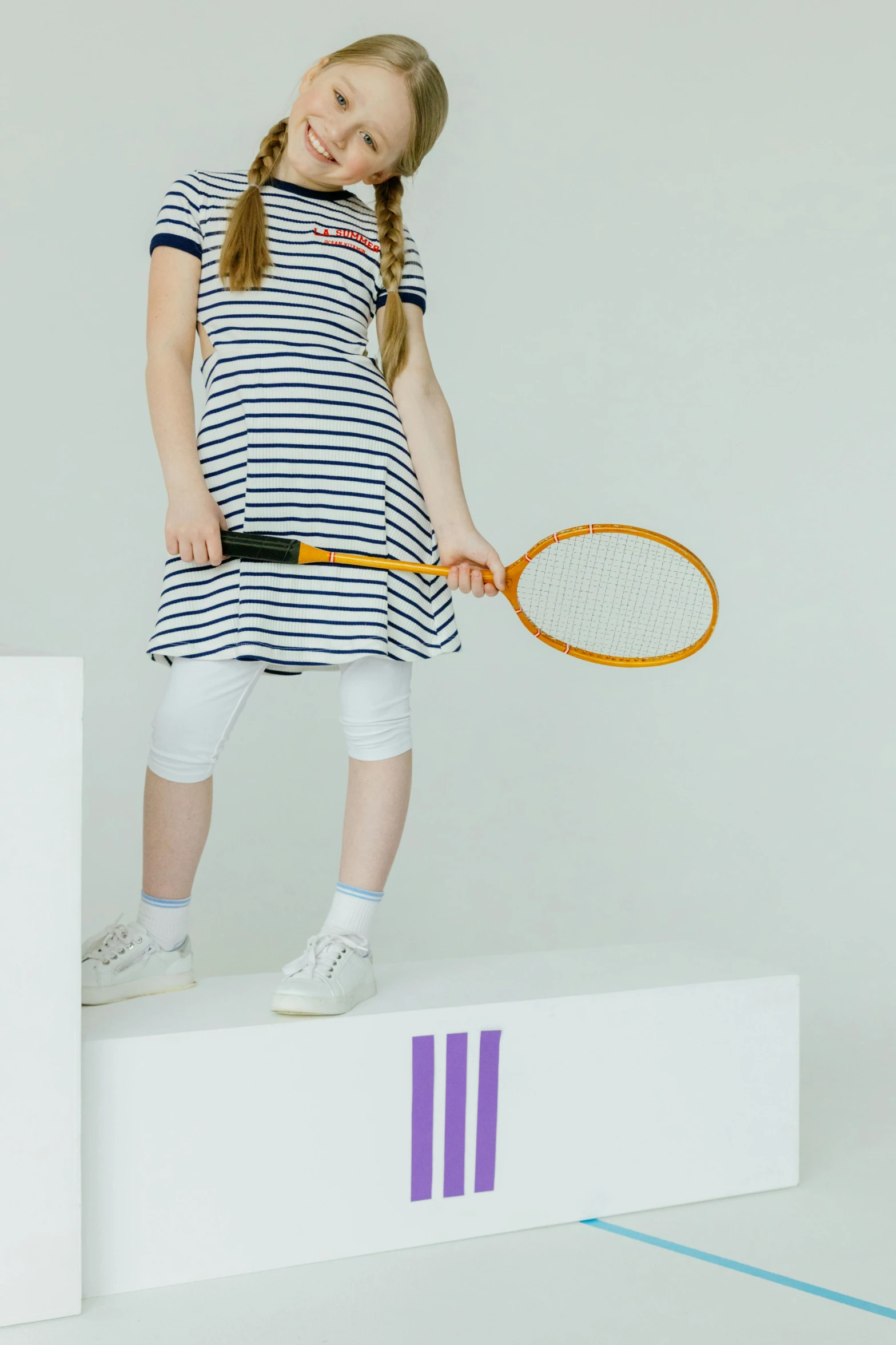 a  holding a tennis racquet on top of a white box