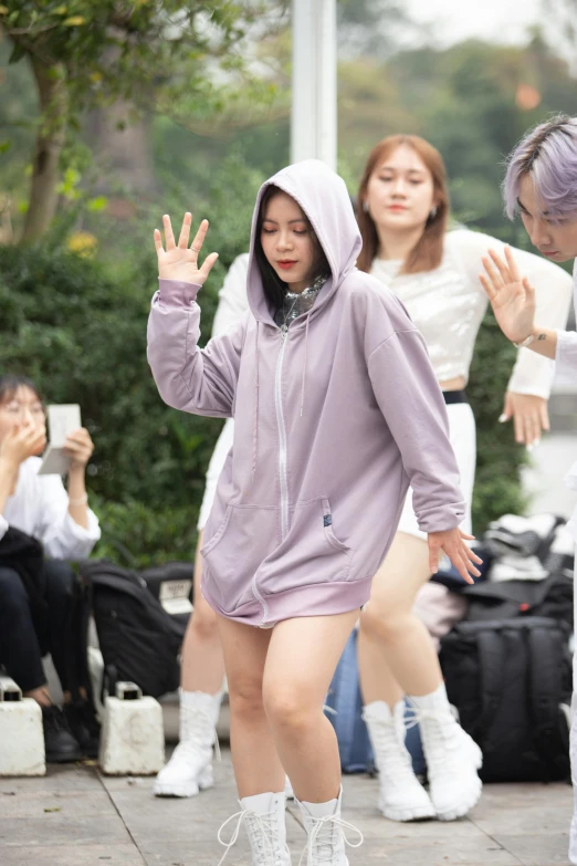 a girl in a hoodie is walking down the street