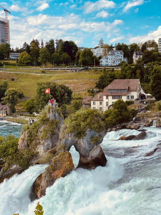 a waterfall and houses with people on the other side