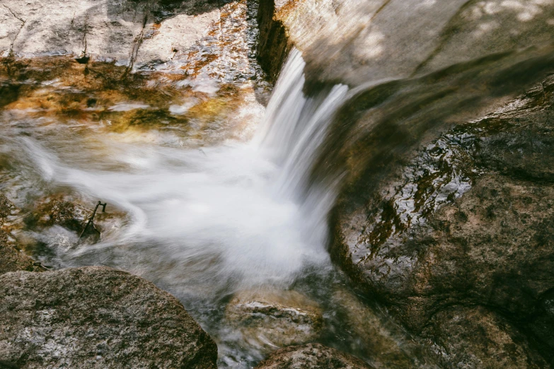 a stream flows through rocks into the river