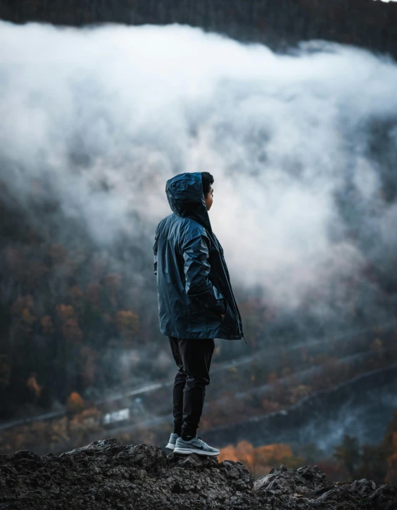 a man standing on a mountain overlooking a valley filled with mountains