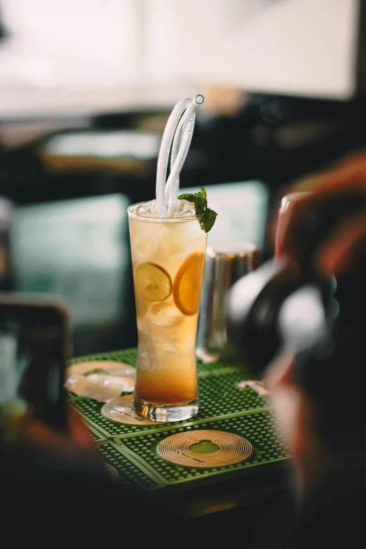 an iced cocktail served on a table with a straw