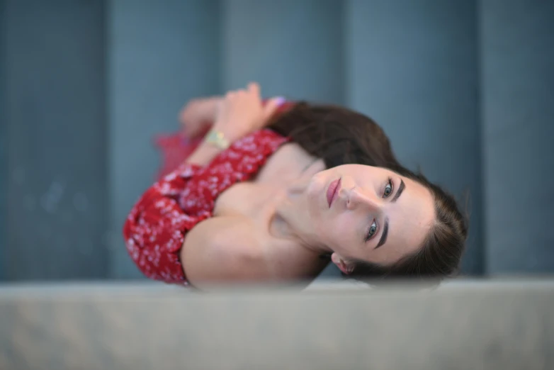 a woman in red dress laying on the ground