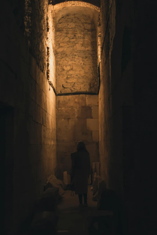 a narrow, dimly lit alleyway with some people in it