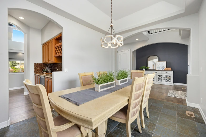 a large dining table with four chairs in a room with a light fixture