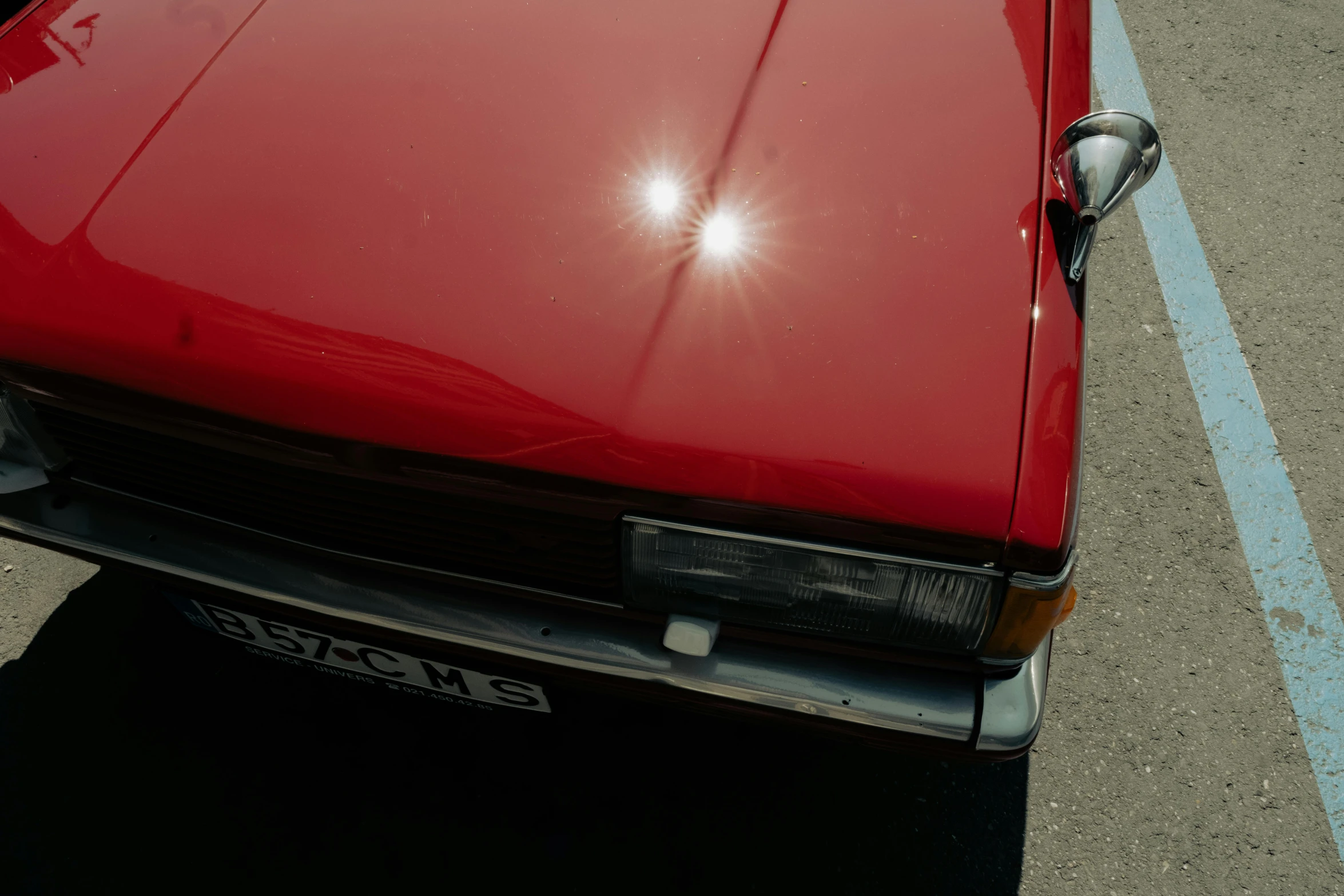 a red car that has some light shining on it