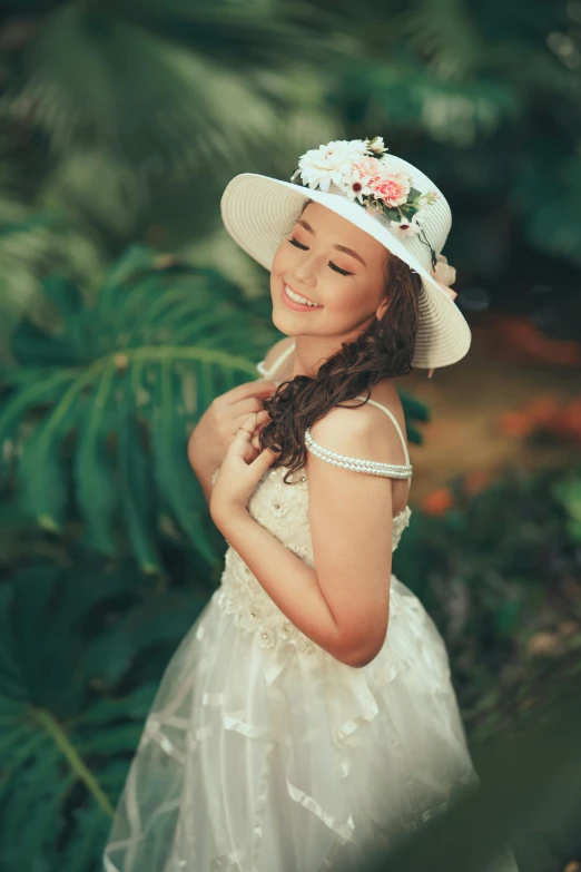 girl with white hat posing in tropical foliage
