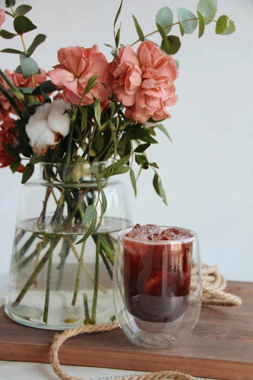 a vase with some pink flowers and a candle