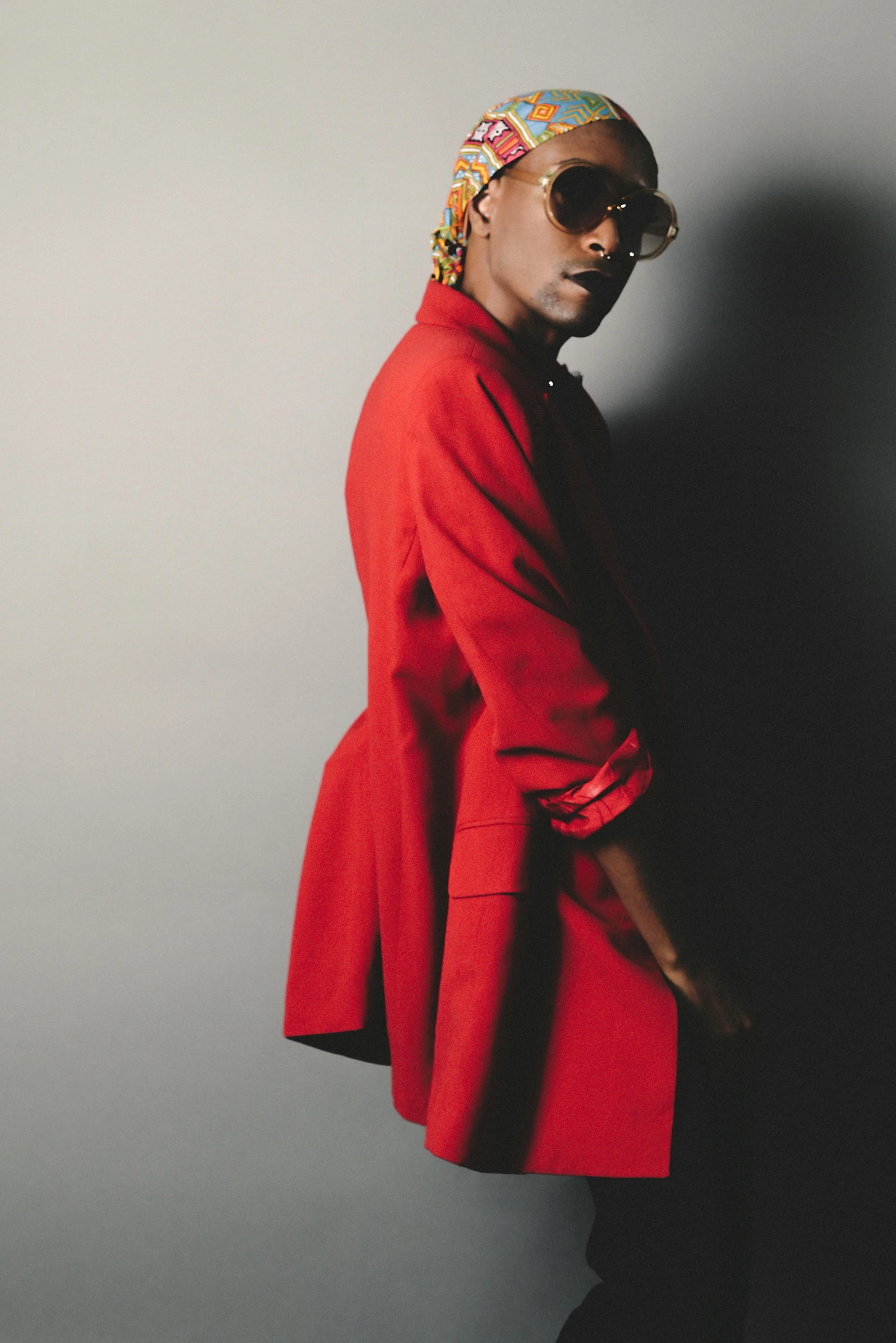 a black woman is posing in front of a wall wearing red