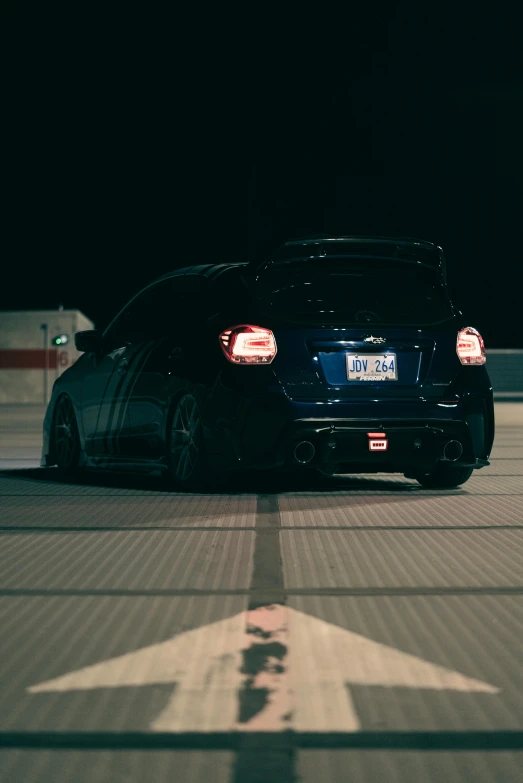 a black sport car on the runway at night