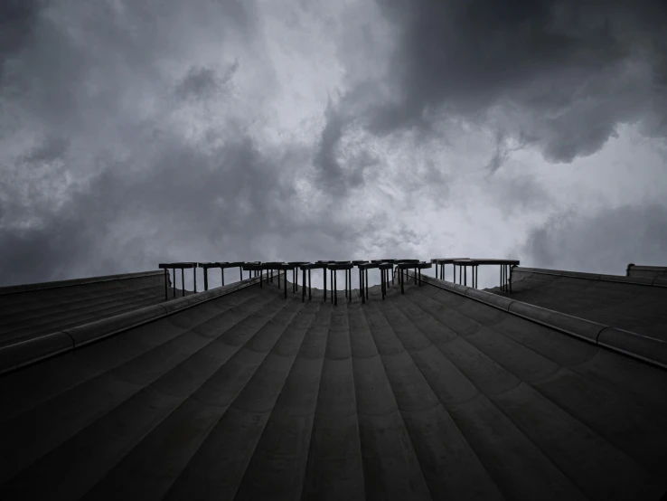 a black and white image of a stairway under a dark cloudy sky