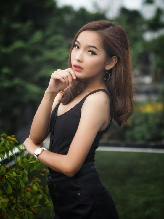 an asian girl with long dark hair and earrings posing for the camera