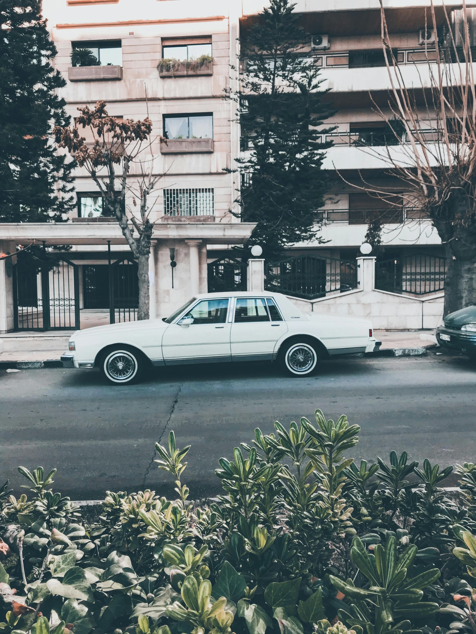 an old car parked near a building in a city