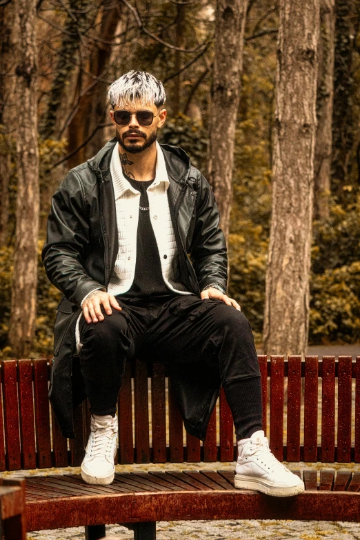 a man with a tie and sunglasses sitting on a wooden bench