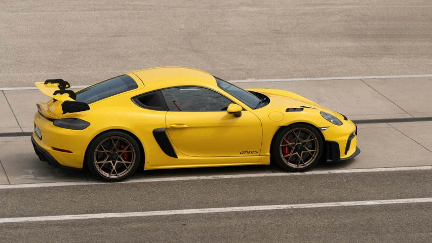 a yellow sports car driving on the street