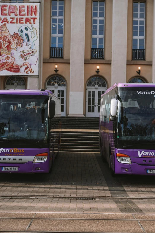 two buses sitting next to each other near stairs