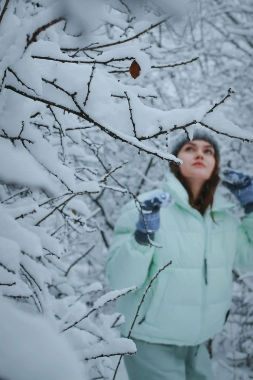 the woman in snow suit has her hand up