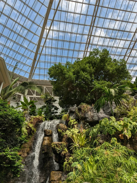 view of a waterfall from inside a large glass covered building