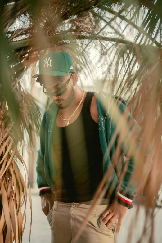 a man standing under a palm tree and posing