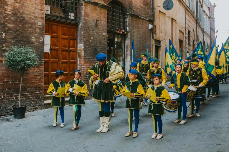 a marching band in green and yellow marching uniforms on the street