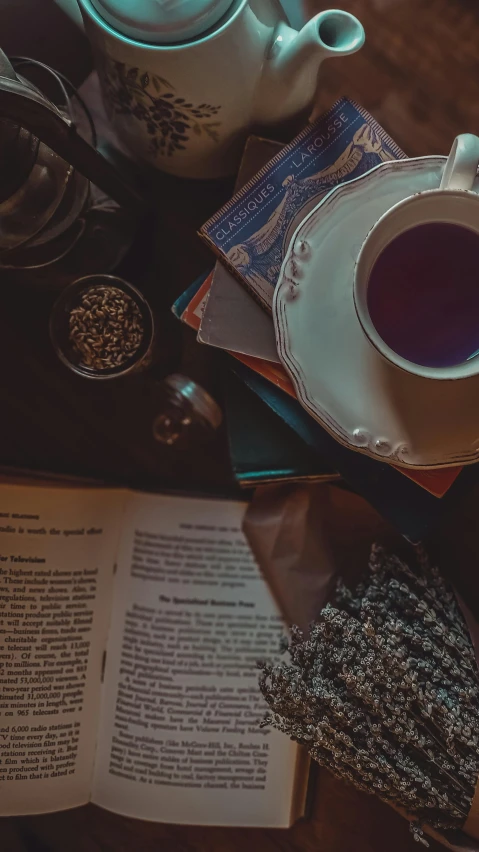 a cup of tea sitting on top of a wooden table next to a book